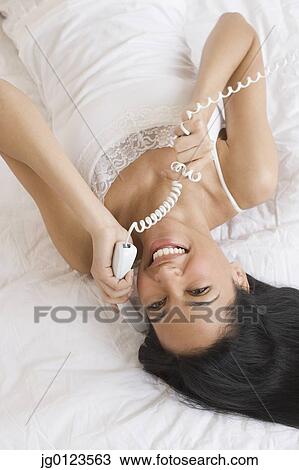 Stock Image - High angle view of African woman talking on telephone. Fotosearch