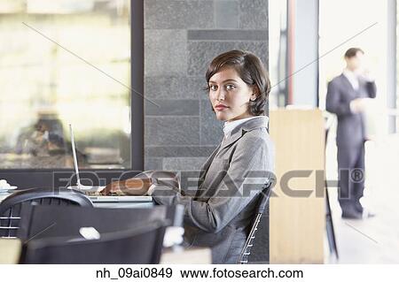 Stock Photo - Hispanic businesswoman typing on laptop at cafe. Fotosearch