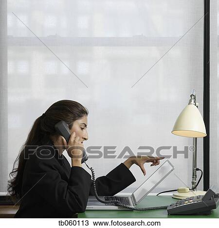 Stock Image - Indian businesswoman talking on telephone. Fotosearch