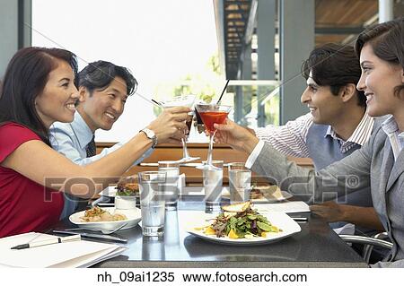 Stock Photography - Multi-ethnic friends toasting at restaurant. Fotosearch