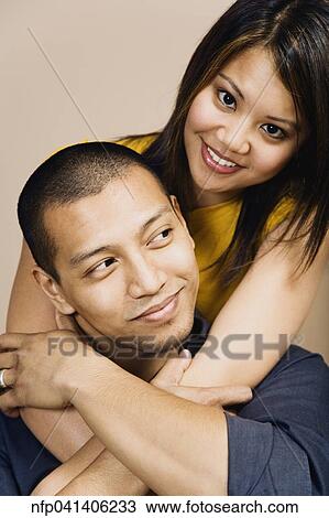 Stock Image - Portrait of Asian couple hugging. Fotosearch