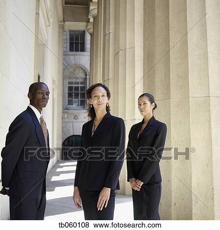 Stock Photo - Portrait of businesspeople standing next to columns. Fotosearch