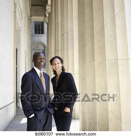 Stock Photo - Portrait of businesswoman and businessman next to columns. Fotosearch