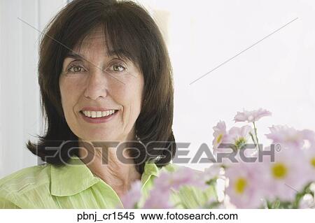 Stock Photography - Portrait of senior woman and flowers. Fotosearch