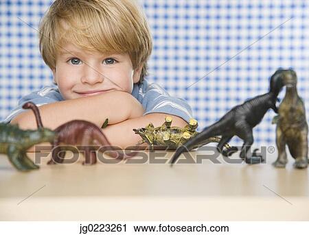 Portrait of young boy with toy dinosaurs View Large Photo Image Stock Image - Portrait of young boy with toy dinosaurs. Fotosearch