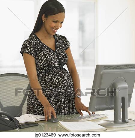 Pregnant African businesswoman at desk View Large Photo Image Stock Photo - Pregnant African businesswoman at desk. Fotosearch