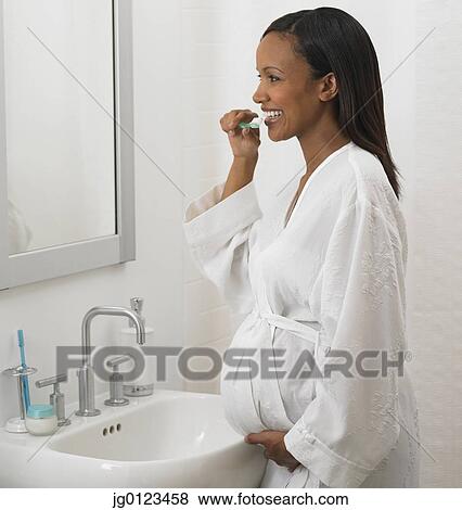 Pregnant African woman brushing teeth View Large Photo Image Stock Photo - Pregnant African woman brushing teeth. Fotosearch
