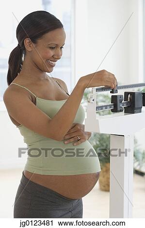 Pregnant African woman on scale View Large Photo Image Stock Image - Pregnant African woman on scale. Fotosearch