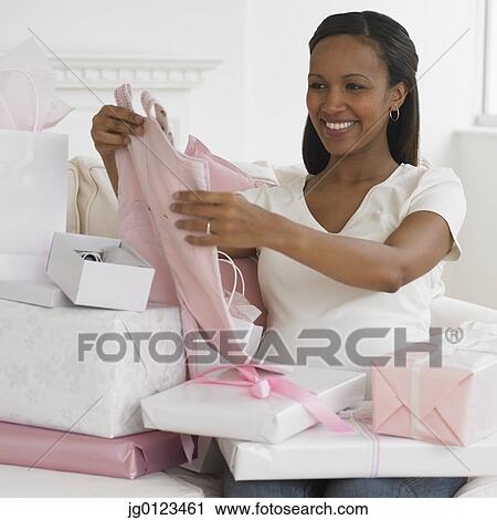 Pregnant African woman opening gifts View Large Photo Image Stock Image - Pregnant African woman opening gifts. Fotosearch
