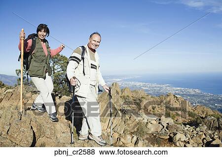 Senior couple hiking on cliffs View Large Photo Image Stock Photo - Senior couple hiking on cliffs. Fotosearch