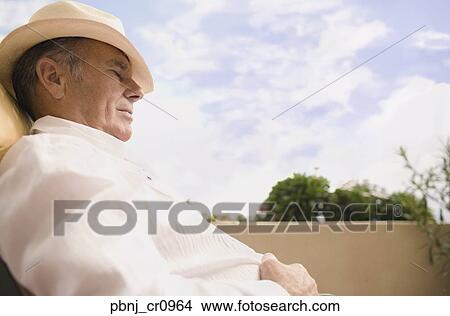 Senior man sleeping in chair outdoors View Large Photo Image Picture - Senior man sleeping in chair outdoors. Fotosearch