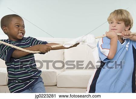 Two young boys playing tug of war View Large Photo Image Stock Image - Two young boys playing tug of war. Fotosearch