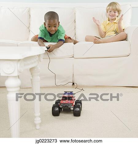 Two young boys playing with remote control car View Large Photo Image Stock Image - Two young boys playing with remote control car. Fotosearch