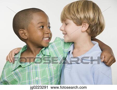 Two young boys smiling at each other View Large Photo Image Stock Image - Two young boys smiling at each other. Fotosearch