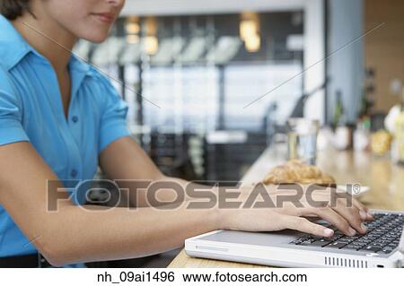 Woman typing on laptop at restaurant View Large Photo Image Stock Photograph - Woman typing on laptop at restaurant. Fotosearch