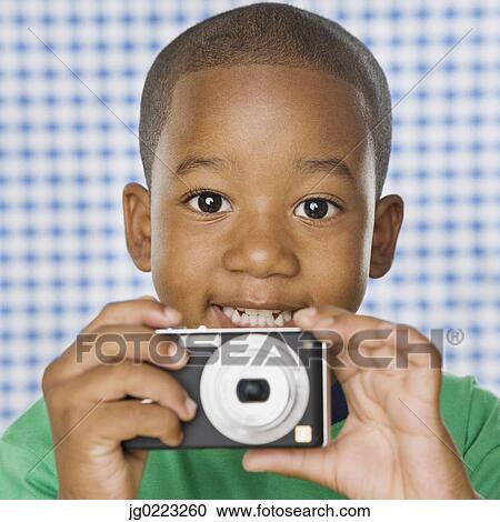 Young African boy holding camera View Large Photo Image Stock Image - Young African boy holding camera. Fotosearch