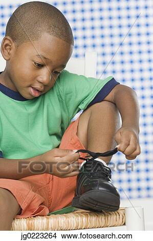 Young African boy tying shoe View Large Photo Image Picture - Young African boy tying shoe. Fotosearch