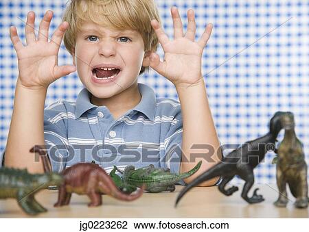 Young boy making face with toy dinosaurs View Large Photo Image Stock Image - Young boy making face with toy dinosaurs. Fotosearch