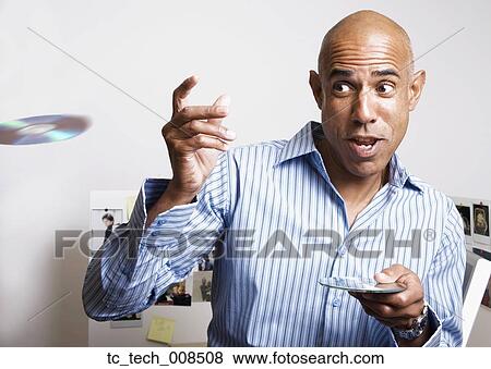 Stock Photo - African businessman throwing cds in office. Fotosearch