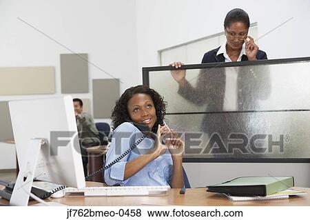 African businesswoman filing fingernails with boss watching View Large Photo Image Stock Photo - African businesswoman filing fingernails with boss watching. Fotosearch
