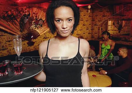 Stock Photo - African cocktail waitress holding tray of drinks. Fotosearch