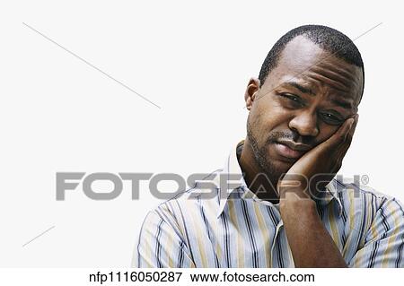 Stock Photo - African man leaning face on hand. Fotosearch