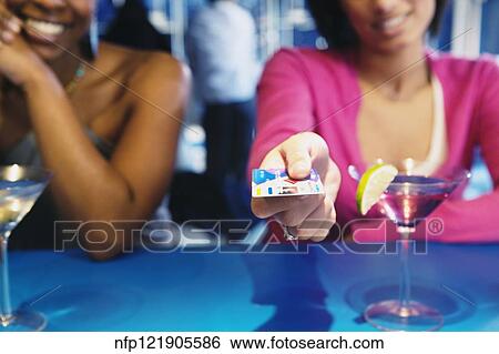 African woman handing credit card over bar View Large Photo Image Stock Photograph - African woman handing credit card over bar. Fotosearch
