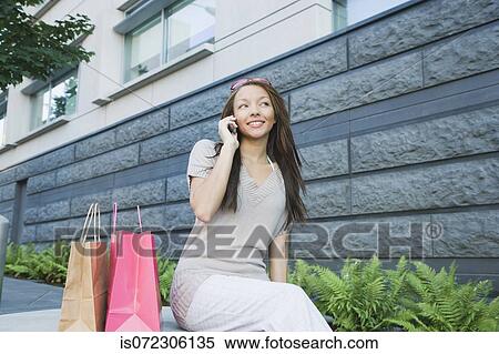 African woman with shopping bags talking on cell phone View Large Photo Image Stock Photography - African woman with shopping bags talking on cell phone. Fotosearch
