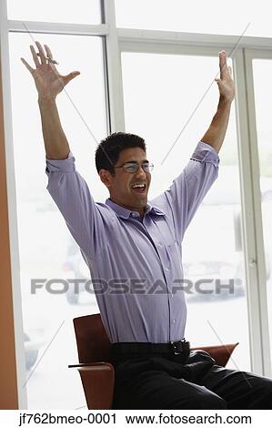 Stock Image - Asian businessman cheering in office. Fotosearch
