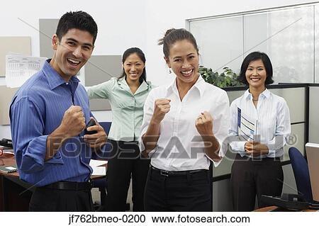 Stock Image - Asian businesspeople cheering in office. Fotosearch
