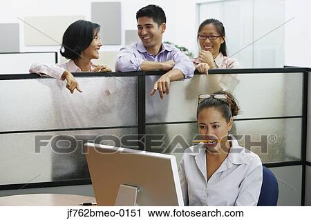 Stock Image - Asian businesspeople pointing at businesswoman. Fotosearch