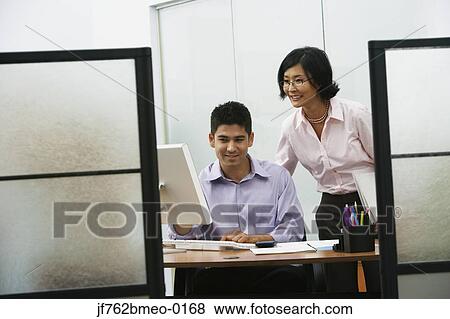 Asian businesswoman and businessman looking at computer View Large Photo Image Stock Photo - Asian businesswoman and businessman looking at computer. Fotosearch