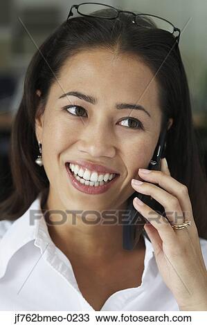 Stock Image - Asian businesswoman talking on cell phone . Fotosearch
