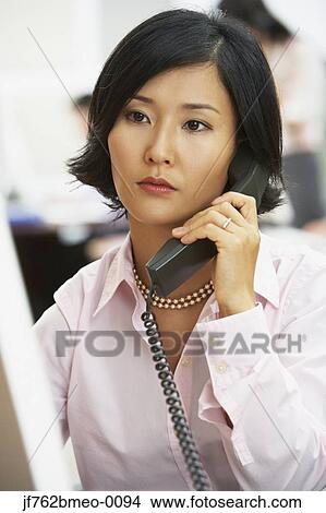 Picture - Asian businesswoman talking on telephone. Fotosearch