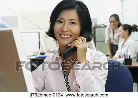 Asian businesswoman talking on telephone View Large Photo Image Picture - Asian businesswoman talking on telephone. Fotosearch