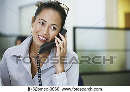 Stock Photo - Asian businesswoman talking on telephone. Fotosearch
