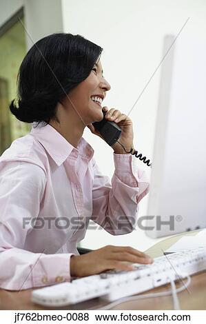 Stock Photo - Asian businesswoman talking on telephone. Fotosearch