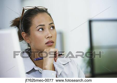 Asian businesswoman thinking at desk View Large Photo Image Stock Photo - Asian businesswoman thinking at desk. Fotosearch