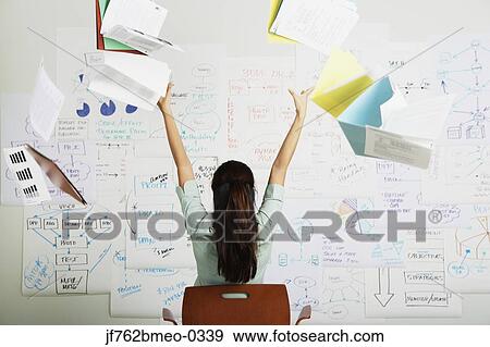 Stock Photo - Asian businesswoman throwing files in air in front of flow chart. Fotosearch