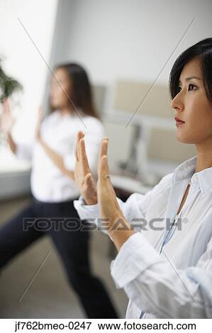 Stock Photo - Asian businesswomen practicing tai chi. Fotosearch