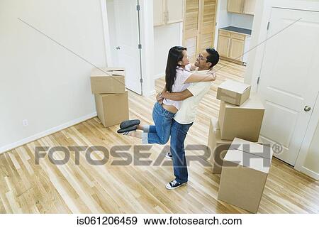 Stock Photo - Asian couple hugging in new house . Fotosearch