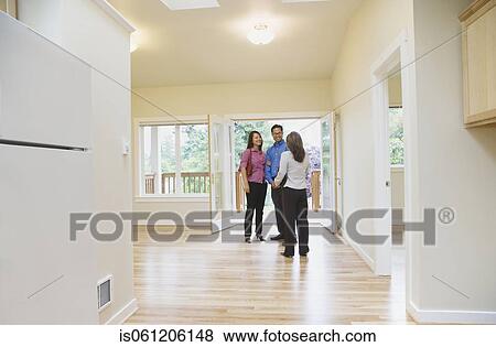 Stock Photo - Asian couple looking at new house. Fotosearch