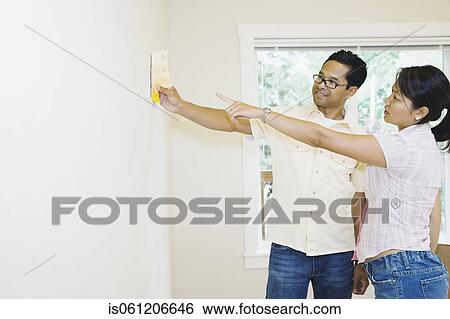Asian couple looking at paint swatches in new house View Large Photo Image Stock Photograph - Asian couple looking at paint swatches in new house. Fotosearch