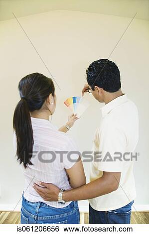 Asian couple looking at paint swatches in new house View Large Photo Image Stock Photograph - Asian couple looking at paint swatches in new house. Fotosearch