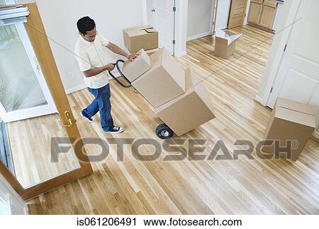 Asian man moving boxes in new house View Large Photo Image Stock Image - Asian man moving boxes in new house. Fotosearch