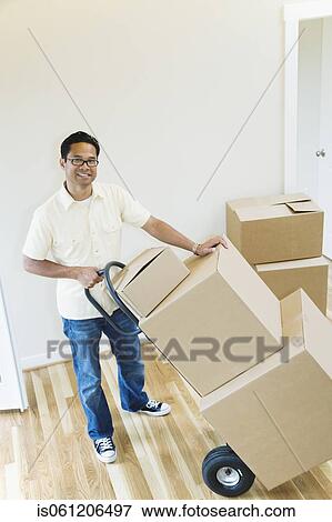 Asian man moving boxes in new house View Large Photo Image Stock Photo - Asian man moving boxes in new house. Fotosearch