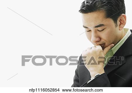 Picture - Asian man resting chin on fist. Fotosearch