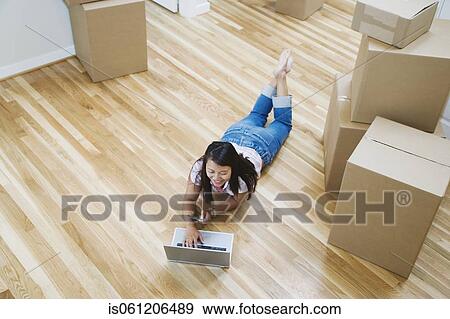 Asian woman looking at laptop in new house View Large Photo Image Stock Photo - Asian woman looking at laptop in new house . Fotosearch