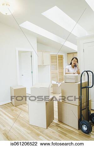 Asian woman talking on cell phone in new house View Large Photo Image Stock Image - Asian woman talking on cell phone in new house. Fotosearch