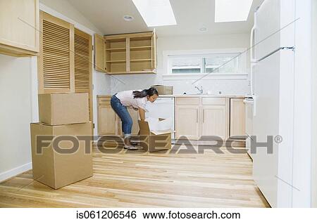 Asian woman unpacking boxes in new house View Large Photo Image Stock Photograph - Asian woman unpacking boxes in new house. Fotosearch